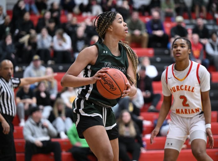 Laurel's Saniyah Hall looks to pass in a game against Purcell Marian on January 11, 2023 as Dee Alexander of Purcell Marian tries to read where it will go.
